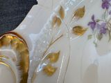 a white plate with purple flowers on it sitting on a table