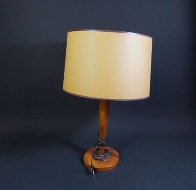 a wooden table lamp with a beige shade on a black background