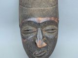 gros plan d'un masque en bois sur une surface blanche