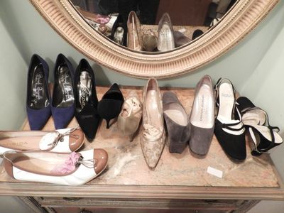 several pairs of shoes are lined up on a table in front of a mirror
