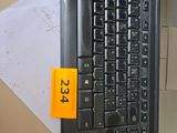 a computer keyboard sitting on top of a desk next to a computer monitor