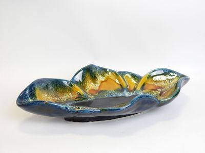 a blue and yellow bowl on a white surface