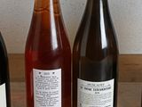 several bottles of wine are lined up on a wooden table