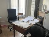 a desk with two chairs and a desk top with papers on it