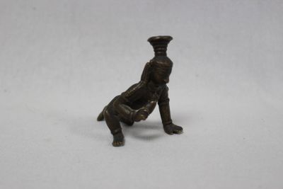 une vieille figurine en bronze représentant un homme assis sur une chaise