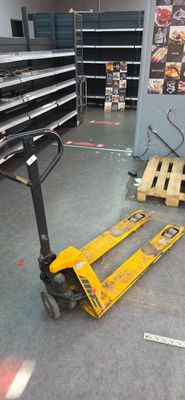 a forklift in the middle of a room with a lot of boxes on the floor