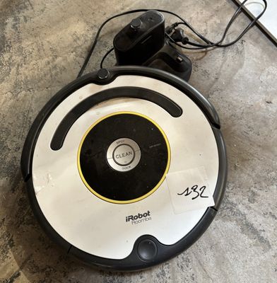 a close up of a robot on the floor with a cord