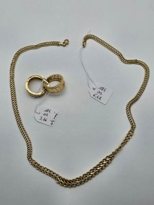 a close up of a gold chain with a ring on it