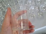 a person holding a wine glass in front of a bunch of wine glasses