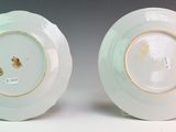 two white plates with gold rims are sitting side by side
