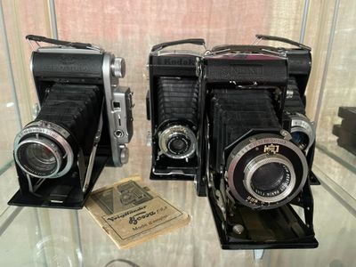 deux vieux appareils photo exposés sur une table en verre