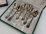 six silver spoons in a box on a table