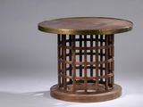 La table est en bois et possède un plateau rond.