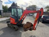 an image of a small excavator parked in a parking lot