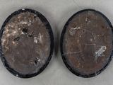 pair of two black and brown oval shaped objects on a white surface