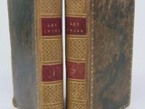 two old books sitting side by side on a white surface