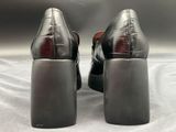 pair of women ' s black leather shoes on a white surface