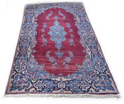 un tapis oriental sur fond blanc, bordé d'une frise bleue