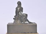 a statue of a woman sitting on top of a table