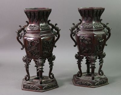 pair of antique chinese vases on pedestals against a gray background