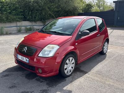 une petite voiture rouge garée sur un parking