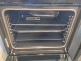 a silver oven with four trays of food inside of it