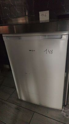 a small white refrigerator in the corner of a kitchen