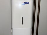 a toilet with a paper towel dispenser on top of it