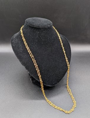 un collier à chaîne en or dans la vitrine d'un mannequin