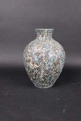 a blue and white vase sitting on a black surface