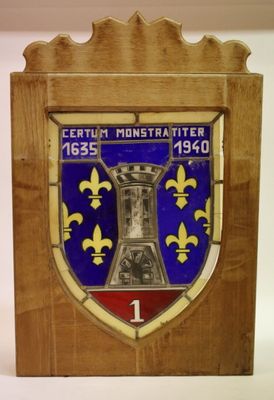 plaque en bois ornée d'un blason bleu et jaune et d'un drapeau rouge et blanc