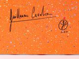 an orange card with a signature of a man on it