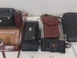 un tas de vieux appareils photo posés sur une table