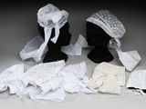 deux mannequins noirs vêtus de vêtements blancs et portant un chapeau blanc