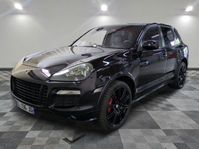 the black porsche cayen is parked on a checkered floor