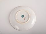 a white plate with a flower on it on a table