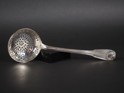 un gros plan d'une cuillère en argent posée sur une surface noire