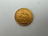 a close up of a gold coin on a white surface