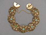 un gros plan d'un bracelet en or orné de pierres de turquoise