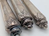 three silver spoons sitting next to each other on a table