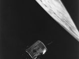 une photo en noir et blanc d'une station spatiale avec un satellite en arrière-plan