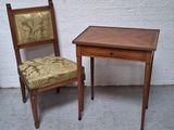 deux chaises et une petite table posées sur le sol en béton