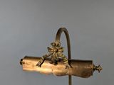 brass plated desk lamp with a monkey holding a bottle on it