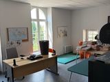 une pièce équipée d'un bureau, de chaises et d'une télévision