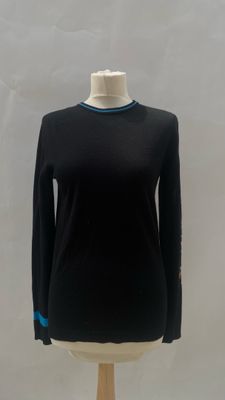 black sweater with blue trims on a mannequin base