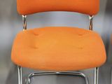 pair of orange chairs with chrome legs on a white background