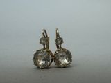une paire de boucles d'oreilles en diamant posées sur une surface grise
