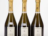 trois bouteilles de champagne posées côte à côte sur une table