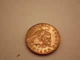 a small coin on a white surface with a white background