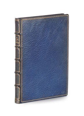 an old book with a blue cover sitting on top of a white surface